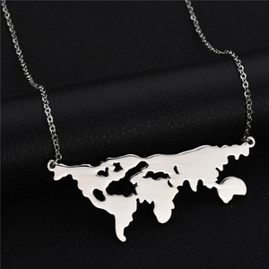 Macro detail of silver world map pendant with polished hollow cut design on leather