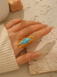 Dettaglio dell'anello largo in acciaio placcato oro 18k con intarsio in pietra turchese