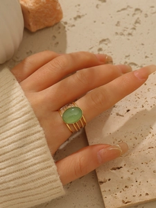 Vista dettagliata dell'anello multistrato placcato oro 18k con pietra verde sulla mano
