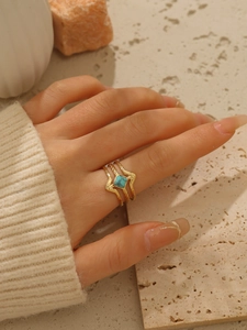 Dettaglio dell'anello multistrato in acciaio placcato oro 18k con turchese quadrato