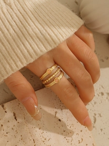 Dettaglio del set di tre anelli placcati oro 18k con pietra rosa e trama a corda ritorta