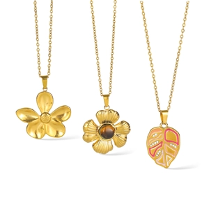 Three gold-plated stainless steel necklaces with floral and leaf pendants on white background