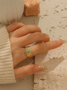 Dettaglio anello in acciaio inossidabile dorato 18k con pietra turchese e rilievo a sole