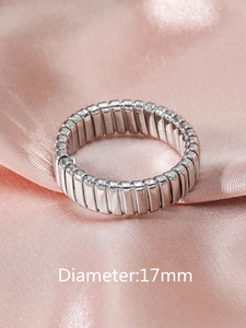 Detail shot of a 17mm diameter flexible ribbed silver ring on pink satin fabric