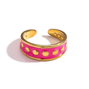 Vue détaillée d'une bague en C dorée avec émail rose et points en relief dorés