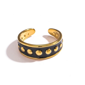 Détail d'une bague en acier inoxydable plaqué or 18k avec émail noir et pois