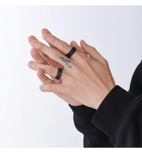Close-up of minimalist matte black rings worn on fingers for a sleek and modern look