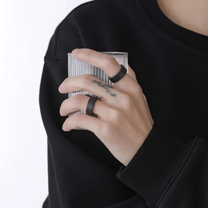 Minimalist matte black ceramic texture ring for men and women worn on a finger