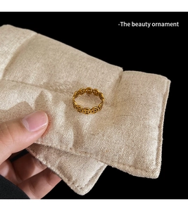Detail of golden ring with traditional coin patterns on a linen display pad