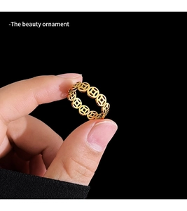 Macro shot of gold hollow coin ring featuring traditional Chinese wealth motifs