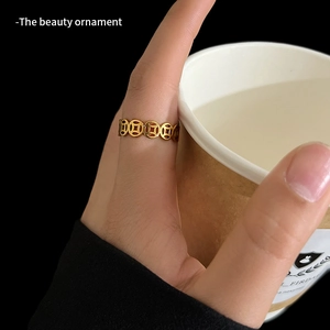 Golden hollow ring with traditional coin patterns for luck, set on a dark background