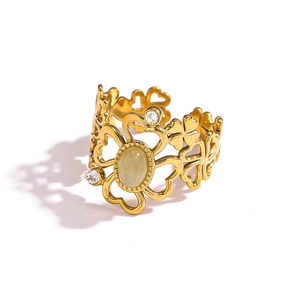 Detailed view of vintage gold hollowed floral ring with light green stone and white accents