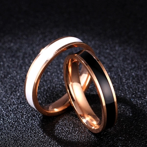 Detailed macro view of interlocking rose gold couple rings with black and white enamel