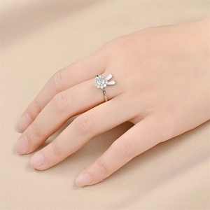 Draaiende konijnenring voor dames in zilver met witte emaille oren op gebreide achtergrond