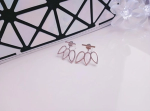 Close-up of minimalist hollow flower stud earrings in silver finish with soft floral decor