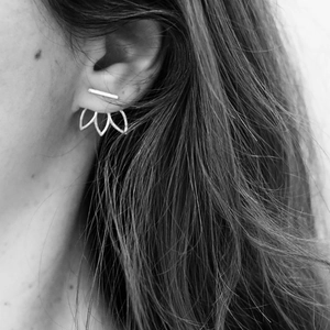 Minimalist 316L stainless steel flower ear jacket studs shown on model ear