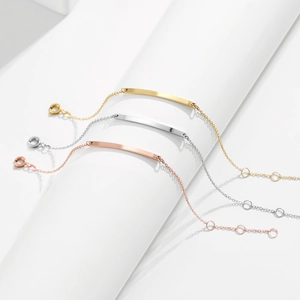 Gedetailleerd macrozicht op minimalistische ID-armbanden in goud, zilver en roosgoud