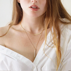 Minimalist double-layered gold stainless steel necklace with bar pendants on model