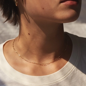 Détail du collier à maillons trombone plaqué or 14K minimaliste sur un cou
