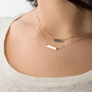 Collier double rang doré avec pendentif barre lisse et perles grises élégantes