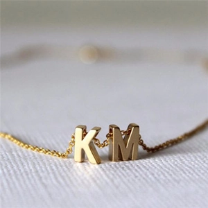 Golden stainless steel letter pendant necklace featuring 3D initials K and M on fine chain