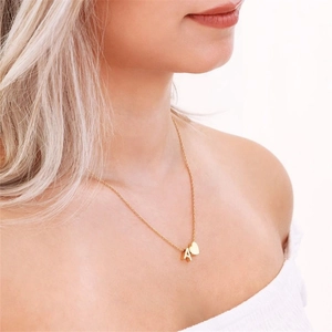 Primo piano della collana placcata in oro con lettera A e ciondolo a cuore su modella