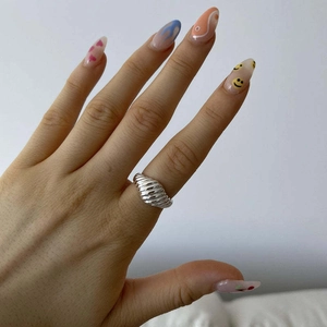 Detalle de cerca de un anillo croissant de plata con textura retorcida en la mano
