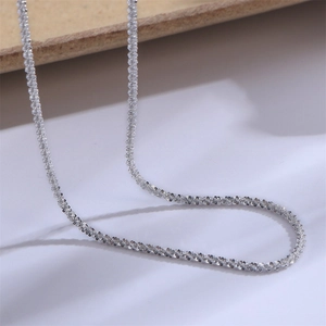 Macro detail of shining silver cauliflower chain necklace with brilliant cut metal texture