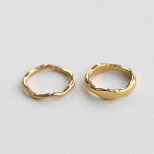 Detailed macro view of minimalist 18K gold-plated stainless steel irregular wavy rings
