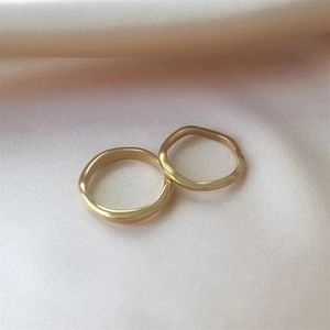 Polished 18K gold plated stainless steel wave and smooth ring set on pink silk