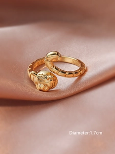 Macro detail of 18KGP gold tiger head open ring with textured band on satin
