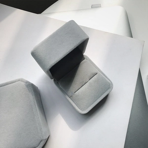 Macro shot of a grey velvet jewelry gift box showing open and closed flip-top states