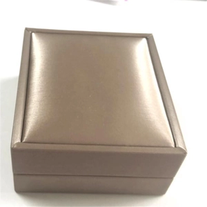 Detail view of a luxury champagne gold jewelry gift box with elegant stitched edges