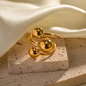 Macro detail of gold plated irregular triple sphere ring on stone with silk fabric