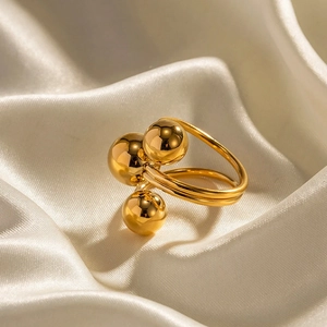 Detailed macro shot of gold-plated spherical ring on elegant white silk background