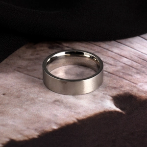 Detail van de mat geborstelde textuur van een 6mm roestvrijstalen ring op vintage decor