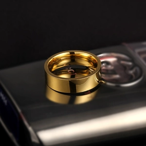 Macro-opname van een gepolijste gouden titanium ring op een zwart reflecterend vlak