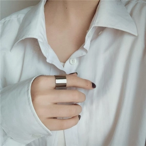 Dettaglio di un ampio anello minimalista in acciaio inossidabile argento al dito