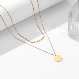 Elegante 18k vergoldete doppellagige Halskette mit rundem Anhänger und Stab auf weißem Grund