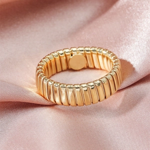 Macro view of a gold-plated Tubogas style textured ring on a premium silk background
