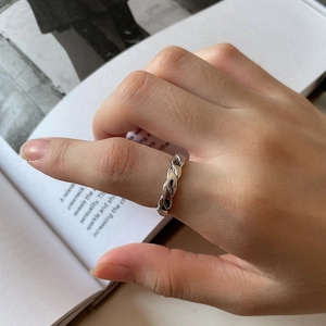 Macro shot of silver twisted rope ring in mirror-polished finish on a model hand