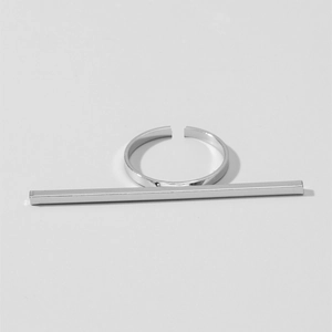 Dettaglio di un anello aperto in argento lucido con barra dal design geometrico minimalista