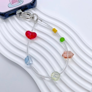 Dragonne de téléphone en perles colorées avec breloques cœur sur fond blanc texturé