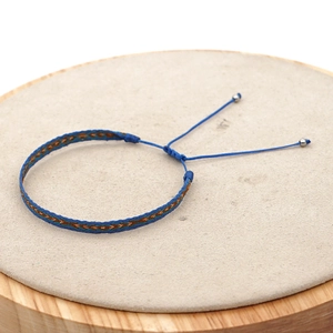 Detail eines bohemischen handgewebten Armbands mit geometrischen Mustern und Kordel