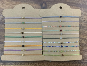 Dettaglio di braccialetti intrecciati in perline Miyuki e pietre naturali su cartoncini