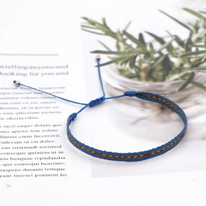Detailed shot of ethnic woven friendship bracelet with adjustable knot on magazine