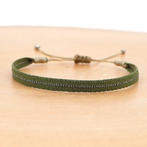 Macro view of army green woven bracelet with silver thread and adjustable drawstring