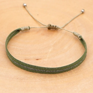 Detail of army green woven bracelet with silver metallic thread and adjustable knot clasp