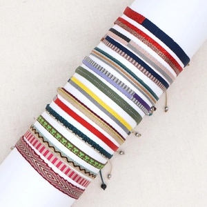 Close-up of colorful Bohemian woven bracelets with ethnic patterns on a white display