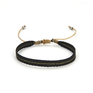 Detailweergave van geweven etnische armband met verstelbaar koord en zilveren metalen kralen